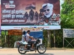A motorcyclist drives past a poster of Prime Minister Modi in Dantewada district in Chhattisgarh.