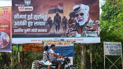 A motorcyclist drives past a poster of Prime Minister Modi in Dantewada district in Chhattisgarh. A motorcyclist drives past a poster of Prime Minister Modi in Dantewada district in Chhattisgarh.