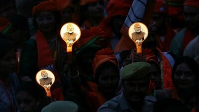 Supporters of Bharatiya Janata Party (BJP) holding campaign materials with pictures of India's Prime Minister Narendra Modi take part in a roadshow, in Varanasi on May 13, 2024, during ongoing India's general election. ( (Photo by Niharika KULKARNI / AFP))