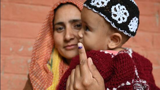 A voter holding up her inked finger after casting her ballot for the Lok Sabha polls. (Waseem Andrabi/HT)
