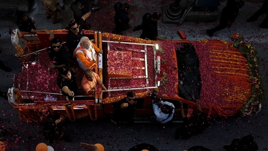 Prime Minister Narendra Modi and UP chief minister Yogi Adityanath wave towards their supporters during a roadshow as part of an election campaign, in Varanasi, India, May 13.(REUTERS/Adnan Abidi)
