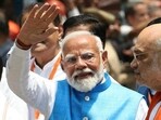 Prime Minister Narendra Modi waving to supporters as Union home minister Amit Shah looks on. Prime Minister Narendra Modi waving to supporters as Union home minister Amit Shah looks on.