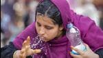 A woman splashes water on her face to get some respite from the scorching heat in Ahmedabad. (PTI Photo)