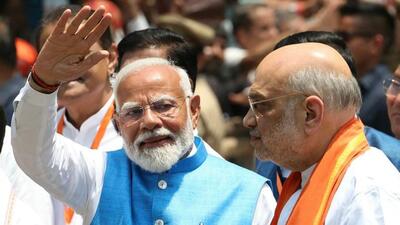 Prime Minister Narendra Modi waving to supporters as Union home minister Amit Shah looks on after the PM filed his nomination papers to recontest the parliamentary seat in Varanasi on Tuesday. (AFP Photo)