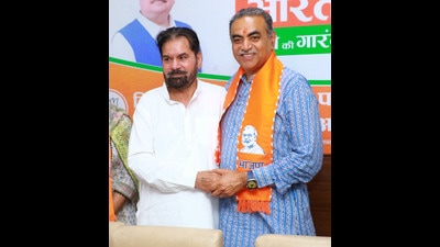 Subhash Chawla with Chandigarh BJP candidate Sanjay Tandon after switching to the saffron fold. (HT Photo)