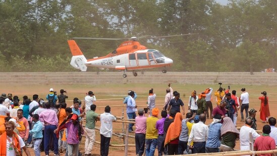 People watch as Assam Chief Minister Himanta Biswa Sarma leaves in a helicopter after a public meeting, in Ramgarh district, Jharkhand.(PTI)
