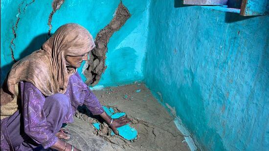 A woman inside her house which developed cracks as the Tangdhar village experience gradual sinking in Udhampur. (ANI)