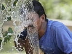 A person splashes water on his face from an irrigation pipe to beat the intense heat wave in Lucknow. (File Photo/AP)