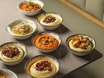 A varied range of hummus laid on a table A varied range of hummus laid on a table