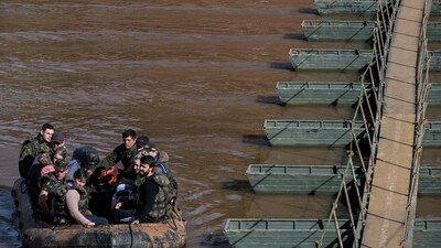 Military personnel help people crossing a boat from Arroio do Meio to Lajeado, over the Forquilha river (AFP) Military personnel help people crossing a boat from Arroio do Meio to Lajeado, over the Forquilha river (AFP)