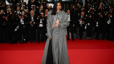 French model Cindy Bruna stunned on the red carpet in a stylish ab-baring zoot suit. Her outfit is from Laruicci’s fall 2024 collection and features floor-skimming trench coat with ’80s-inspired shoulders and utilitarian detailing along the sleeves. Bruna styled it with a matching button-down, which she left partially unbuttoned to show off her toned midsection, and a high-rise maxi skirt. (Photo by CHRISTOPHE SIMON / AFP) French model Cindy Bruna stunned on the red carpet in a stylish ab-baring zoot suit. Her outfit is from Laruicci’s fall 2024 collection and features floor-skimming trench coat with ’80s-inspired shoulders and utilitarian detailing along the sleeves. Bruna styled it with a matching button-down, which she left partially unbuttoned to show off her toned midsection, and a high-rise maxi skirt. (Photo by CHRISTOPHE SIMON / AFP)