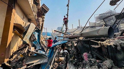 Workers inspect the site of the boiler blast at a factory in Sonepat’s Kundli town on Thursday. (PTI)