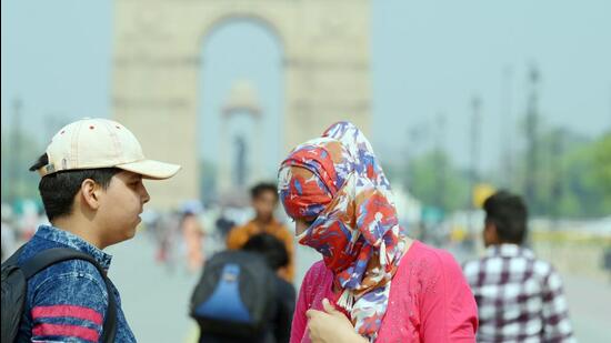 Visitors at Kartavya Path cover up their faces and wear caps to shield themselves from the sun. (Vipin Kumar/HT Photo)
