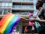Onlookers watch as LGBTQ+ rights activists hold a rally 