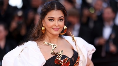 Aishwarya Rai posed for photographers at the premiere of the film Megalopolis at the 77th Cannes Film Festival. She attended the red carpet of the event in a black and gold gown adorned with intricate golden patterns. Her attire, designed by Falguni and Shane, featured a long train embellished with opulent golden flowers. (AP) Aishwarya Rai posed for photographers at the premiere of the film Megalopolis at the 77th Cannes Film Festival. She attended the red carpet of the event in a black and gold gown adorned with intricate golden patterns. Her attire, designed by Falguni and Shane, featured a long train embellished with opulent golden flowers. (AP)