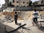 Children stand near a crater caused by Israeli bombardment in a street in Rafah in the southern Gaza Strip Children stand near a crater caused by Israeli bombardment in a street in Rafah in the southern Gaza Strip