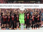 Bayer Leverkusen's Lukas Hradecky celebrates with the trophy and teammates after winning the Bundesliga and going unbeaten 