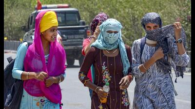 Commuters cover their faces on a hot day in Amritsar on Saturday. (PTI) Commuters cover their faces on a hot day in Amritsar on Saturday. (PTI)