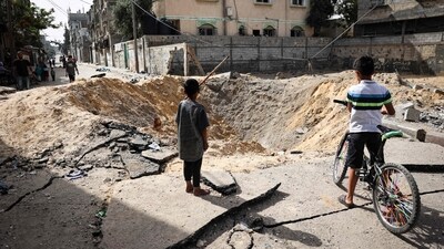 Children stand near a crater caused by Israeli bombardment in a street in Rafah in the southern Gaza Strip (AFP) Children stand near a crater caused by Israeli bombardment in a street in Rafah in the southern Gaza Strip (AFP)