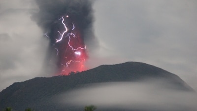Lightning appears amid a storm as Mount Ibu spews volcanic material during an eruption, as seen from Gam Ici in West Halmahera, North Maluku province, Indonesia (via REUTERS)