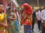 A man carries an elderly voter to cast her ballot at a polling station during the fifth phase of voting in India's general election, in Hajipur on May 20, 2024.(AFP)