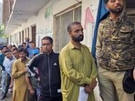 Voters wait in a queue to cast their votes during the fifth phase of Lok Sabha polls, at a polling station in Baramulla.