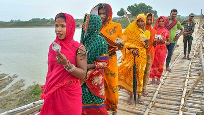 Women cross a bridge on their way to a polling booth in Muzaffarpur, Bihar. (PTI) Women cross a bridge on their way to a polling booth in Muzaffarpur, Bihar. (PTI)