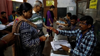 People get their names checked in voters' lists inside a polling station during the fifth phase of India's general election in Howrah district of West Bengal on May 20. (Reuters)