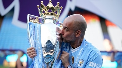 Manchester City's head coach Pep Guardiola celebrates with the Premier League trophy. (AP)