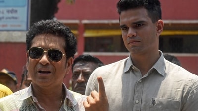 Former Indian cricketer Sachin Tendulkar (L) displays his ink-marked finger after casting his vote with his son Arjun Tendulkar at a polling station during the fifth phase of voting of the Lok Sabha elections 2024 on May 20. (AFP)