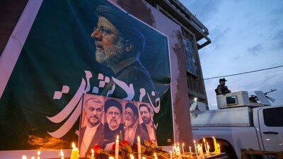 An Iraqi soldier stands guard next candles list by people paying their respects to Iran's late president Ebrahim Raisi outside the Iranian embassy in Baghdad (AFP) An Iraqi soldier stands guard next candles list by people paying their respects to Iran's late president Ebrahim Raisi outside the Iranian embassy in Baghdad (AFP)
