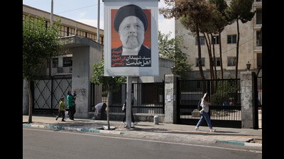 People walk near a banner with a picture of the late Iran's President Ebrahim Raisi on a street in Tehran, Iran on May 20 (via REUTERS/WANA) People walk near a banner with a picture of the late Iran's President Ebrahim Raisi on a street in Tehran, Iran on May 20 (via REUTERS/WANA)