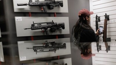 A person looks at guns at an exhibition booth during the annual National Rifle Association (NRA) meeting in Dallas, Texas, U.S., May 17, 2024.   REUTERS/Shelby Tauber (REUTERS)