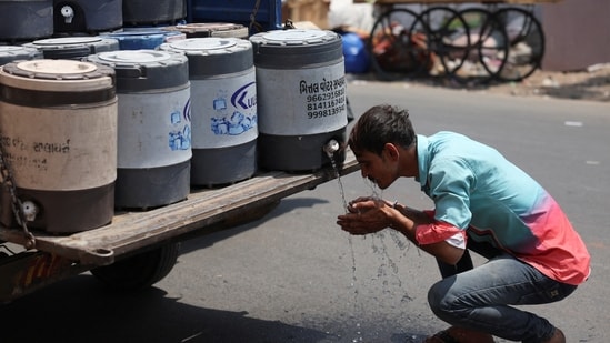 A man sprays cold water on his face in Ahmedabad. (REUTERS)