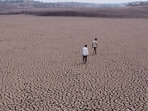 Beed, India. Mar 29,2024 : A man was seen walking on a dry lake at Chandapur village in Beed district. Due to the lack of rain in the state this year, the water level in many lakes in Marathwada has decreased. In the next few months, Marathwada is expected to face a shortage of water. More than 70% of Maharashtra's talukas are facing a drought. As temperatures soar with summer approaching, a water crisis is looming with the live water storage in the state's dams down. The arid Marathwada region has the lowest dam water storage, down to 21.3% of capacity compared with 46% at this time last year. Mar 29,2024. (Photo by Raju Shinde/HT Photo)