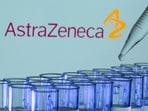 Test tubes are seen in front of a displayed AstraZeneca logo in this illustration.