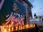 An Iraqi soldier stands guard next candles list by people paying their respects to Iran's late president Ebrahim Raisi outside the Iranian embassy in Baghdad(AFP)