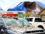 A truck is covered in debris as a families in Bridgeland begin to recover from and clean up storm damage on Sunday, May 19, 2024, in Cypress, Texas. The suburban Houston area of Bridgeland suffered major damage last week after a line of powerful storms, that included a confirmed tornado, swept through the area. (Brett Coomer/Houston Chronicle via AP)