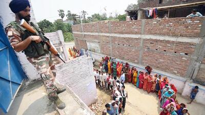 A security official stands guard as people queue up to cast their votes at a polling booth in Saran, Bihar on Monday. (Santosh Kumar/ HT Photo) A security official stands guard as people queue up to cast their votes at a polling booth in Saran, Bihar on Monday. (Santosh Kumar/ HT Photo)