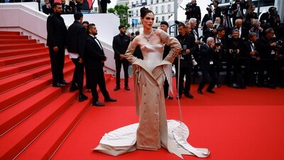 Coco Rocha poses on the red carpet as she arrives for the screening of the film 'The Apprentice'. For her awe-inspiring look, she wears a beige Robert Wun Haute Couture dress with an off-the-shoulder neckline and a unique skirt that appears to be a coat with button detailing and an extended train at the back, oozing drama and sartorial flair. (REUTERS/Clodagh Kilcoyne)