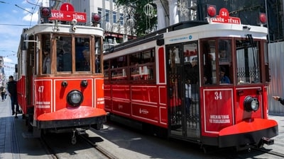 The pictures show a tram powered by traditional overhead power lines (REAR)(L) and a modern battery-powered electric tram (R) waiting at the stop on Istiklal Street, in Istanbul. The iconic red and white tram on Istiklal Street, beloved by tourists makes way for a more modern one while remaining true to the original aesthetics, in Istanbul. (Photo by Yasin AKGUL / AFP) The pictures show a tram powered by traditional overhead power lines (REAR)(L) and a modern battery-powered electric tram (R) waiting at the stop on Istiklal Street, in Istanbul. The iconic red and white tram on Istiklal Street, beloved by tourists makes way for a more modern one while remaining true to the original aesthetics, in Istanbul. (Photo by Yasin AKGUL / AFP)