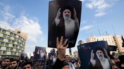 People hold up posters of Iranian President Ebrahim Raisi during a mourning ceremony for him at Vali-e-Asr square in downtown Tehran, Iran, (AP) People hold up posters of Iranian President Ebrahim Raisi during a mourning ceremony for him at Vali-e-Asr square in downtown Tehran, Iran, (AP)