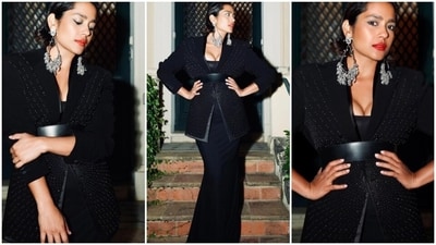 The third look is from the shelves of designer label Rohit Gandhi & Rahul Khanna. It features a bodycon black gown with a plunging neckline, a figure-hugging silhouette, and a floor-length hem. Shahana layered with an embellished black blazer, cinched under the bust with a black leather belt. Meanwhile, statement silver earrings, bold red lip shade, winged eyeliner, gold eye shadow, feathered brows, bronzer on the cheekbones, and a dewy base completed the glam picks. Side-parted loose locks rounded off the hairstyle with the all-black ensemble. (Instagram) The third look is from the shelves of designer label Rohit Gandhi & Rahul Khanna. It features a bodycon black gown with a plunging neckline, a figure-hugging silhouette, and a floor-length hem. Shahana layered with an embellished black blazer, cinched under the bust with a black leather belt. Meanwhile, statement silver earrings, bold red lip shade, winged eyeliner, gold eye shadow, feathered brows, bronzer on the cheekbones, and a dewy base completed the glam picks. Side-parted loose locks rounded off the hairstyle with the all-black ensemble. (Instagram)