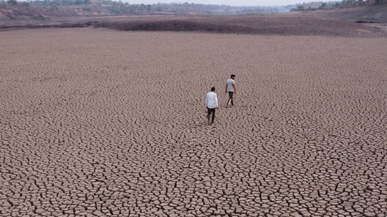Beed, India. Mar 29,2024 : A man was seen walking on a dry lake at Chandapur village in Beed district. Due to the lack of rain in the state this year, the water level in many lakes in Marathwada has decreased. In the next few months, Marathwada is expected to face a shortage of water. More than 70% of Maharashtra's talukas are facing a drought. As temperatures soar with summer approaching, a water crisis is looming with the live water storage in the state's dams down. The arid Marathwada region has the lowest dam water storage, down to 21.3% of capacity compared with 46% at this time last year. Mar 29,2024. (Photo by Raju Shinde/HT Photo)