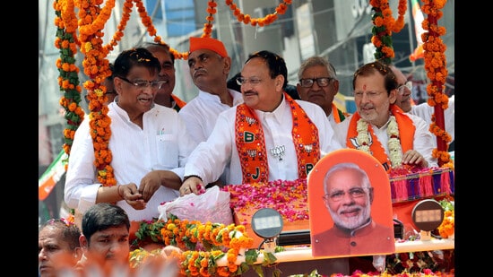BJP national president JP Nadda during a roadshow for party’s Lok Sabha candidate Arvind Sharma (right) in Rohtak on Tuesday. (Manoj Dhaka/HT)