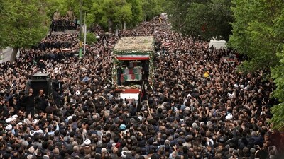 Black-clad mourners beat their chests as they walked behind a lorry carrying the coffins of Raisi and those who died with him. (AP)