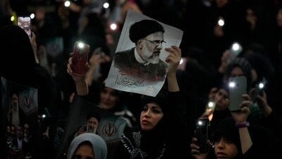 A woman holds up a poster of the late Iranian President Ebrahim Raisi at the mam Khomeini Grand Mosque in Tehran in a funeral ceremony for him and his companions who were killed in a helicopter crash on Sunday in a mountainous region of the country's northwest.&nbsp; (AP)