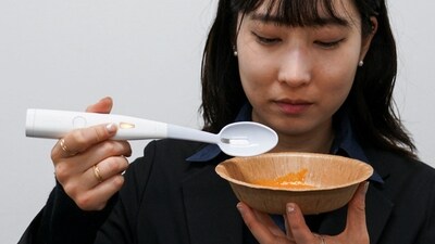 An employee of Kirin Holdings demonstrates an electric spoon. (REUTERS)