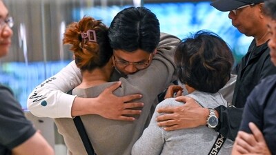 Passengers of Singapore Airlines flight SQ321 from London to Singapore, which made an emergency landing in Bangkok, greet family members upon arrival at Changi Airport in Singapore. (AFP)