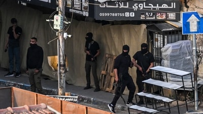 Armed Palestinians take positions during an Israeli raid on the occupied West Bank city of Jenin on May 21, 2024. Palestinian health officials said seven Palestinians were killed on May 21, in an Israeli raid on the West Bank city of Jenin, where an AFP correspondent reported masked gunmen later exchanged fire with Israeli forces. (AFP) Armed Palestinians take positions during an Israeli raid on the occupied West Bank city of Jenin on May 21, 2024. Palestinian health officials said seven Palestinians were killed on May 21, in an Israeli raid on the West Bank city of Jenin, where an AFP correspondent reported masked gunmen later exchanged fire with Israeli forces. (AFP)